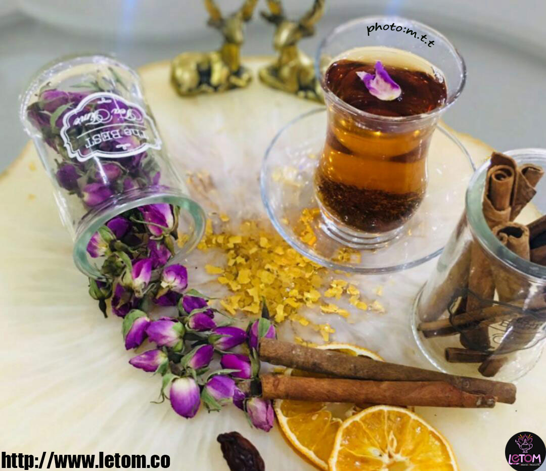Cup of natural damask rose tea with cinnamon and dried fruit