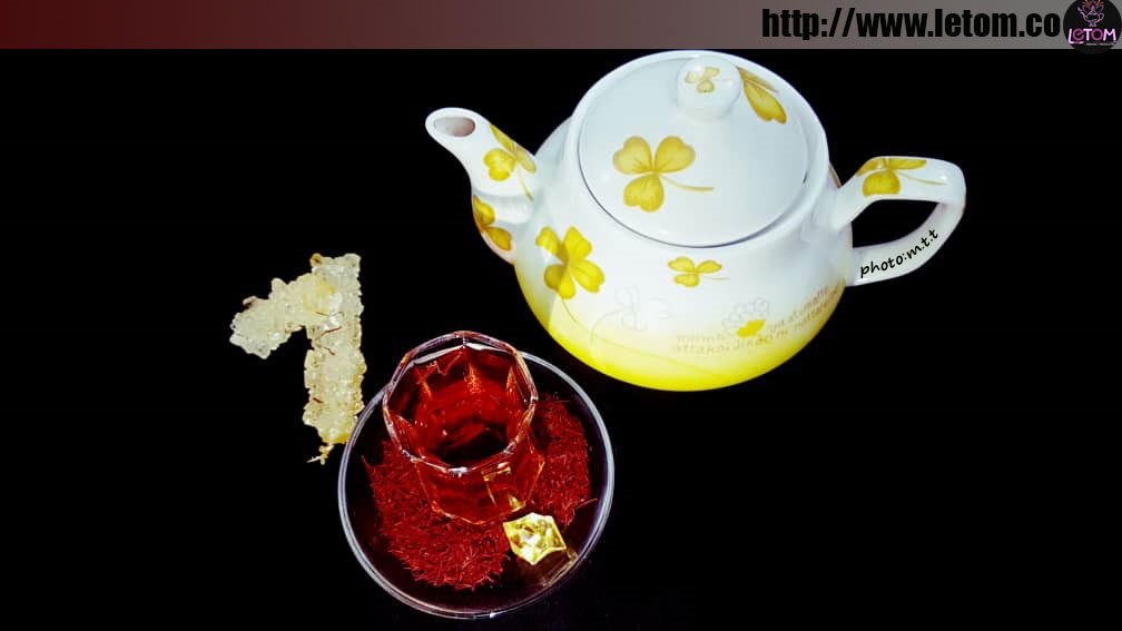 Cup of saffron tea next to the teapot