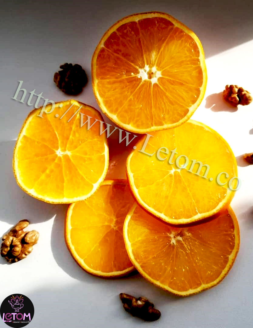 Fresh organic oranges on the table next to walnuts